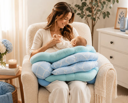 Maman allaitant son nouveau-né avec le coussin d'allaitement 4 positions CoconConfort bleu dans un fauteuil blanc, chambre bébé lumineuse
