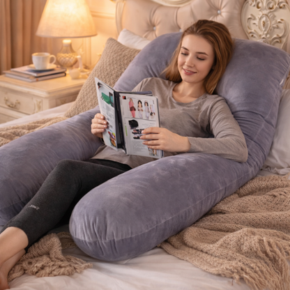 Femme enceinte détendue lisant avec un coussin de grossesse forme G gris offrant un soutien confortable pour le dos et les jambes